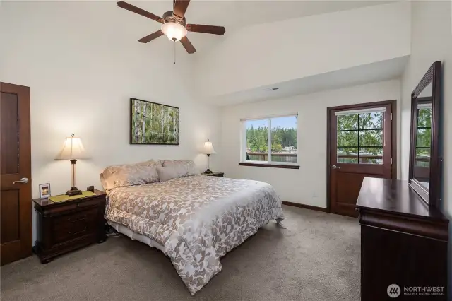 Primary Bedroom ceiling fan, black out blinds and door leading to deck.