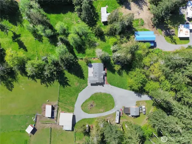 overview of house, circular driveway for easy trailer access, barn and extra large loafing sheds