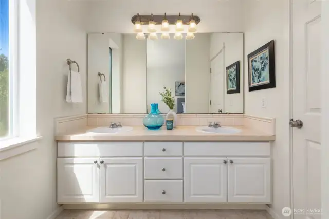 Dual vanity and soaking tub in the primary suite.