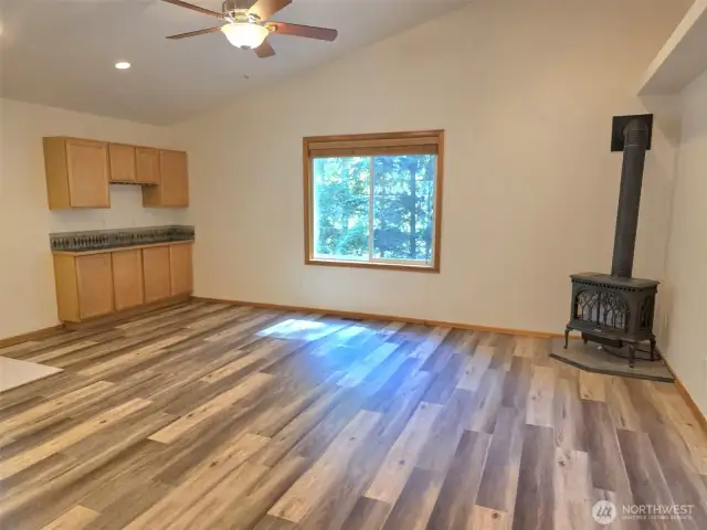 picture window, gas fireplace, side board.  view of lake through the trees.