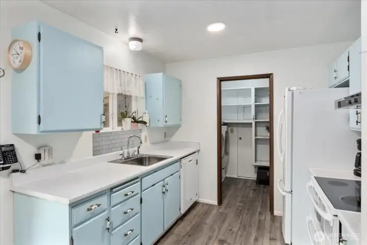 Kitchen features updated LVP flooring and a spacious walk-in pantry and utility room. All appliances stay.