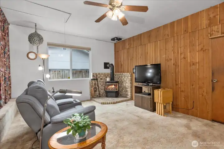 Additional living space with a gas fireplace and fan.