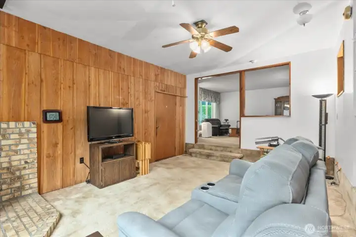 Additional living space with a gas fireplace and fan.