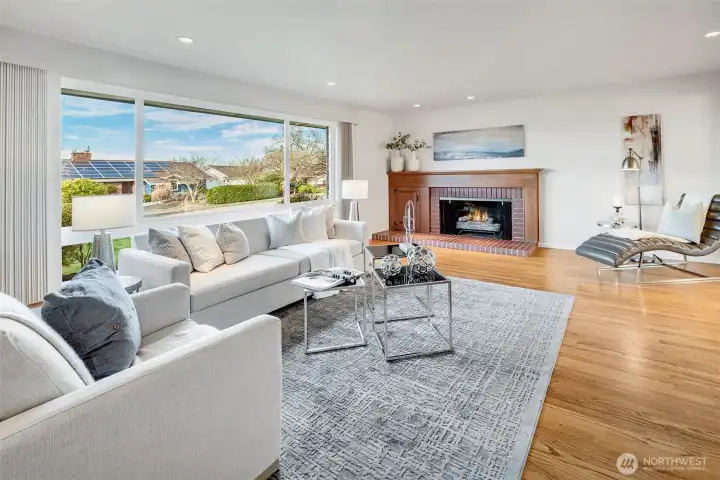 Bright large living room with wood burning fireplace and North facing windows.