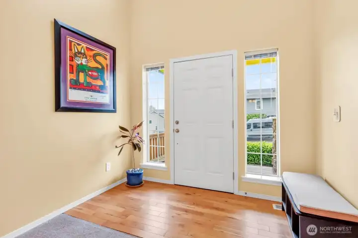 The entry welcomes you with abundant natural light, hardwood flooring, and soaring ceilings for a grand first impression.
