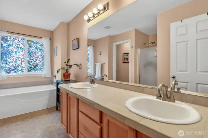 The expansive primary bath offers a true retreat with a separate tub and shower, dual sinks, and a private water closet.