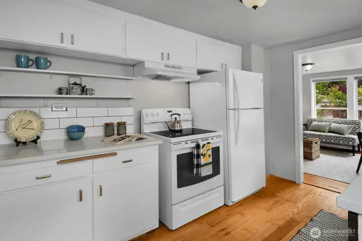 The kitchen has quartz countertops, newer appliances, and plenty of counter and cabinet space