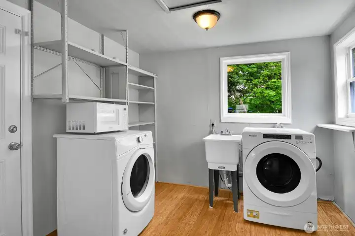 Just off the kitchen is a large utility room with more storage space. The door to the left leads to the lovely back yard.