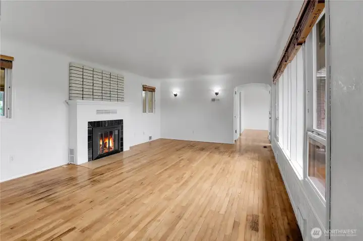 Living room with hardwood floors, wood burning fireplace, and fresh paint!