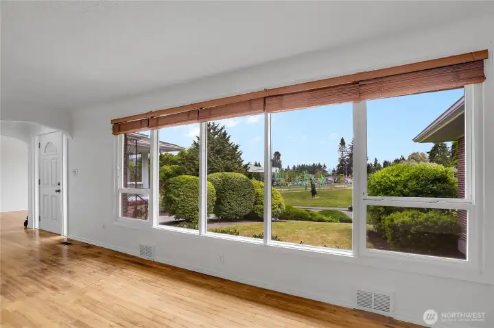 Living room with large windows, hardwood floors, and fresh paint on main level