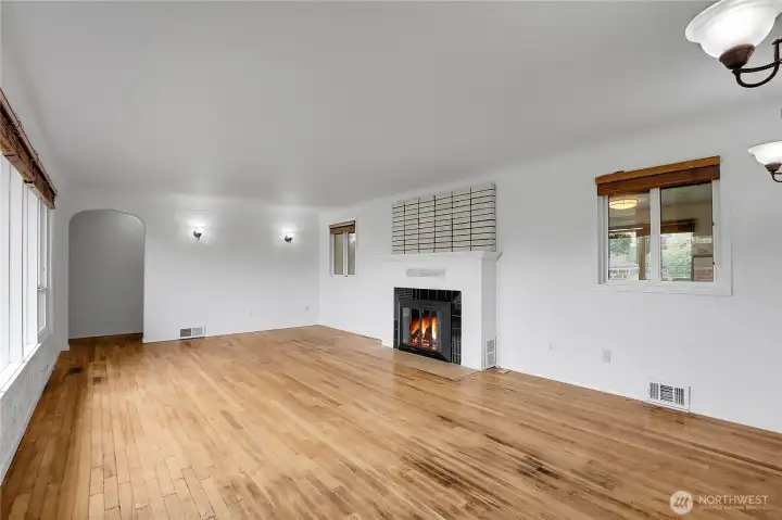 Living room with hardwood floors, wood burning fireplace, and fresh paint on main level