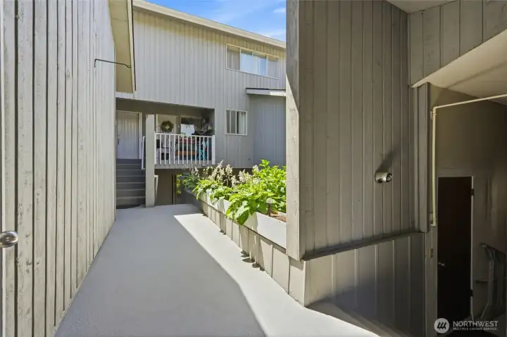 Taken by the secure door looking ahead to the front door of the condo with the garage to your right.