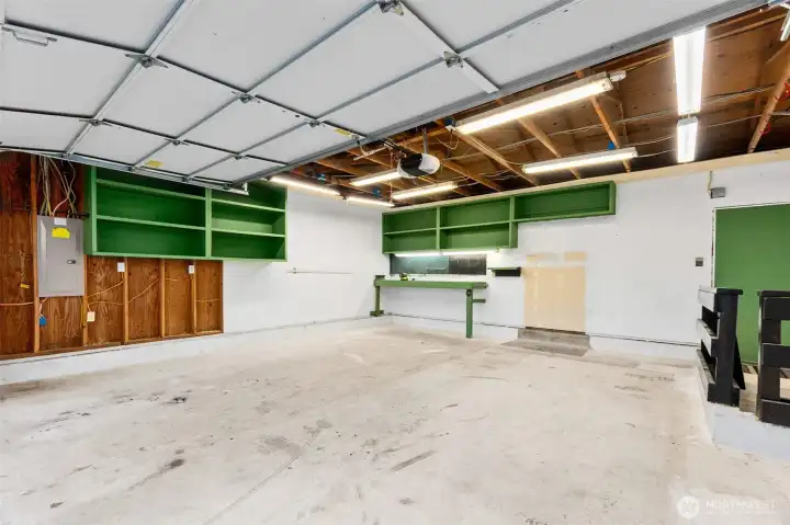 Garage with extra storage, workbench, and pegboard. Garage with extra storage, workbench, and pegboard.