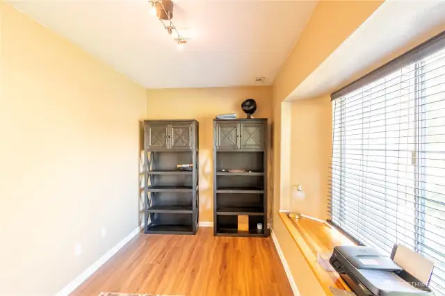 Downstairs office/den/bedroom front of home to the right side of front porch as you are looking at the home. Window seat. Has bathroom attached with walk in shower and access from kitchen or this bonus room on main floor. Nice room if someone needs room with bath and doesn't want stairs.