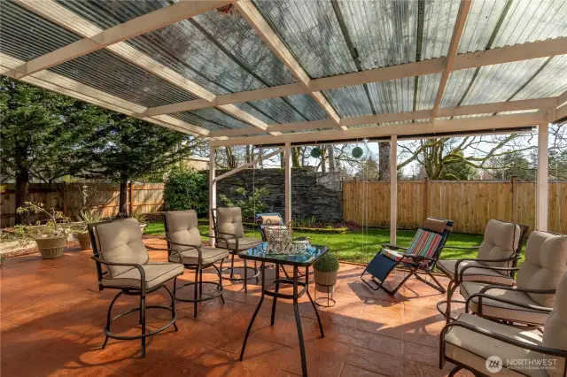 Covered patio with slate wall, cedar fencing and stamped concrete. Wonderful area for entertaining and relaxing.