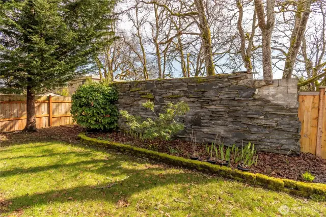 Decorative slate wall with flower beds with iris.