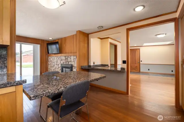 Breakfast bar off the kitchen area, looking into family room and entry to dining area. Slider leads to outdoor patio.