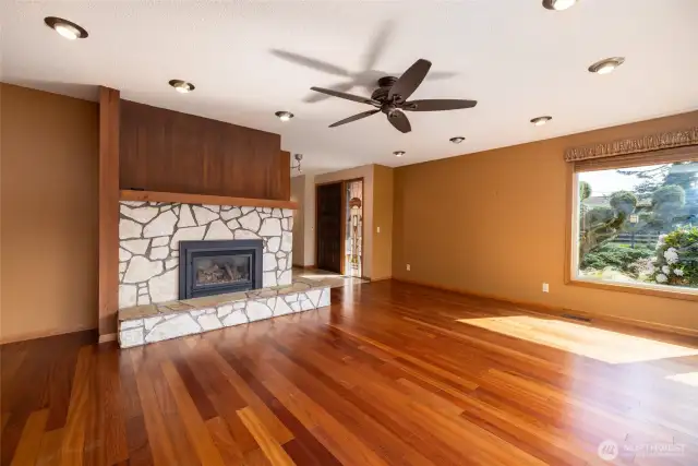 Main living room with beautiful cherry wood flooring and stone fireplace with gas insert