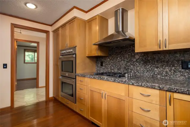 Stainless appliances include double ovens, gas cooktop, range hood and dishwasher.