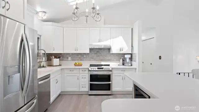 Hello sunshine! This kitchen is filled with natural light from the skylight above, making it a bright and welcoming space. You'll also love the new LVP flooring, installed in 2023!