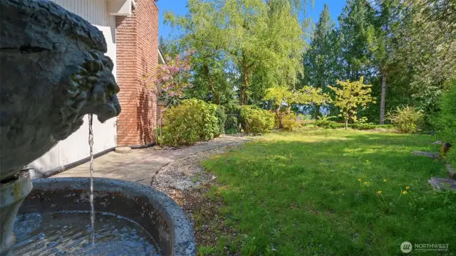 Find your peace in this exquisite side yard! The gentle sound of this fountain, one of three, will instantly transport you to your happy place.