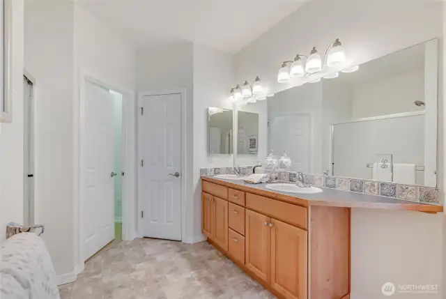 Primary bath with a dual sink vanity, step in shower, large walk-in closet, linen closet and separate water closet.