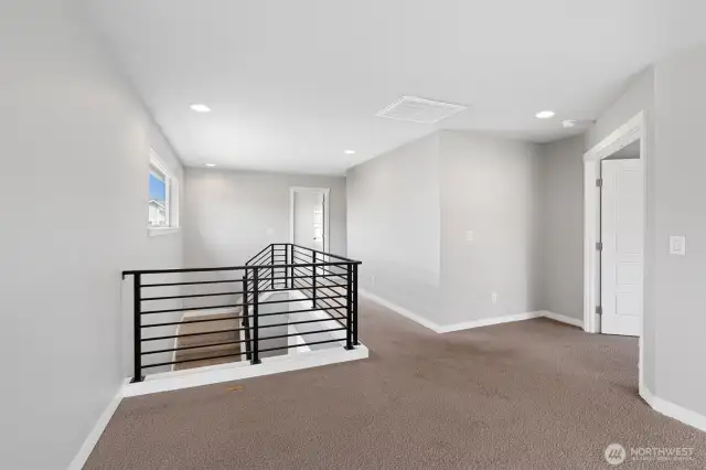 "Huge Bonus room" atop the stairs, with primary room entrance to the right.