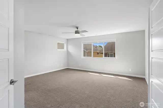 Entering into this warm and inviting primary bedroom with Grand Double French doors!