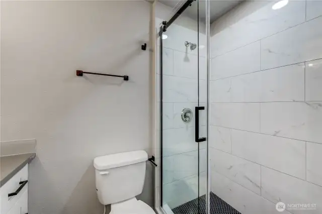 The walk-in shower with sliding glass doors and full tile surround