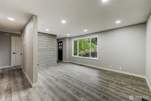 The room’s neutral palette, durable vinyl plank flooring, and custom shiplap accent wall