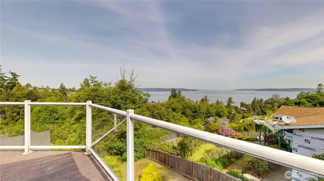 Enjoy panoramic water and tree-lined territorial views from the comfort of your private deck with glass railing.