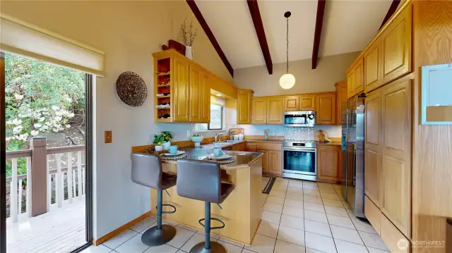 Gourmet kitchen with solid oak upper cabinets, granite tile counters, tile floors, and a built-in pantry.