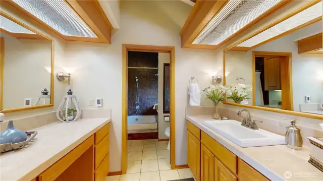 Spacious en-suite bath with dual vanities and warm natural finishes.