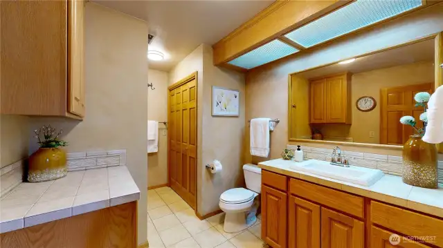 Spacious hall bath with warm wood cabinetry and classic tile finishes.