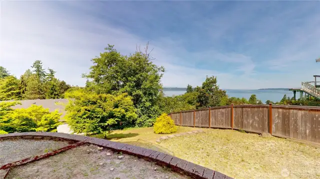 Terraced yard with Puget Sound views and natural privacy. This fenced outdoor space offers a blend of open lawn, mature landscaping, and tiered levels—ideal for gardening, play, or future improvements.