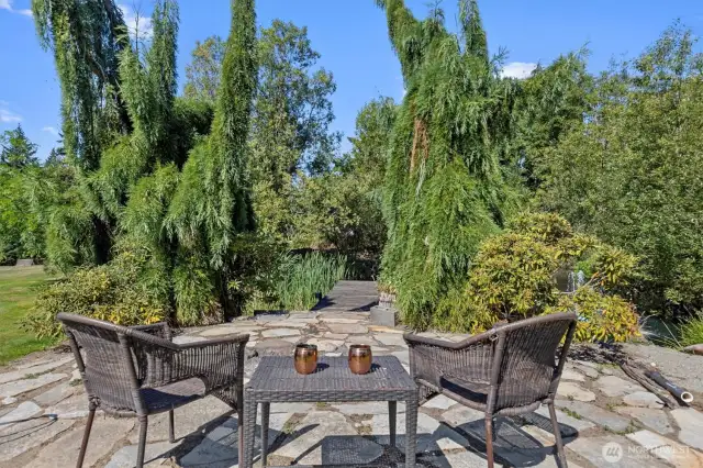 Patio area with fire pit by pond