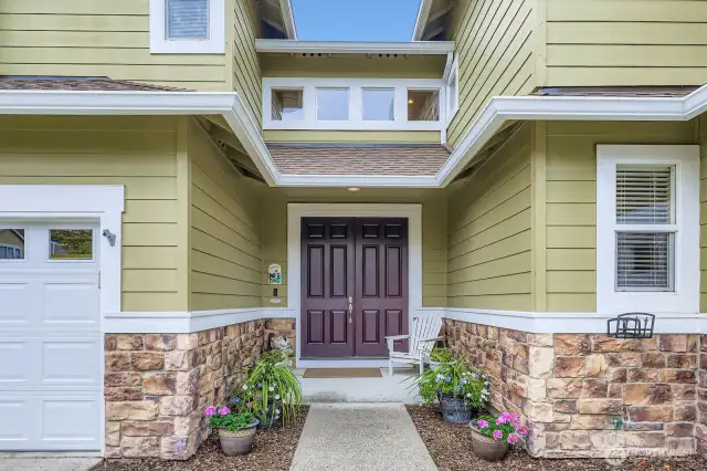 LOVELY FRONT PORCH WITH ROOM FOR PATIO FURNITURE AND FLOWER POTS.