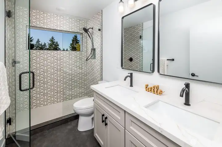Primary bedroom ensuite bathroom with dual sink vanities, and huge walk in shower.  Heated tile floors keep you comfortable and warm, and the tree view is a welcoming site each day.