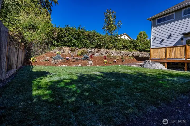 Look at this yard!! Slightly sloped hill to one side for any gardening or creativity, and a level lush lawn for play time and activities!