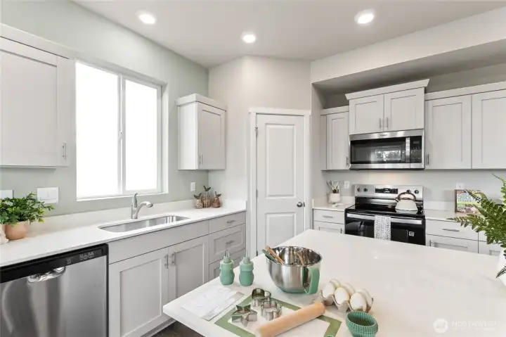 Window over sink adds light to already bright kitchen. Finishes and options will vary.