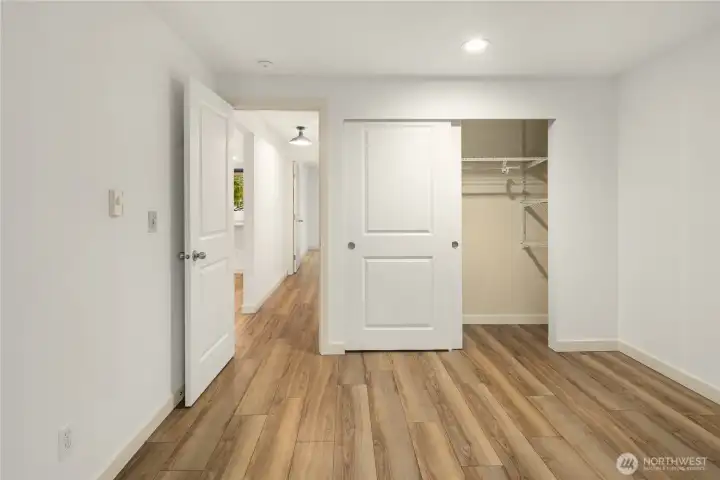 North sided bedroom looking at the closet with convenient shelves/rack inside. Beautiful white sliding closet doors.