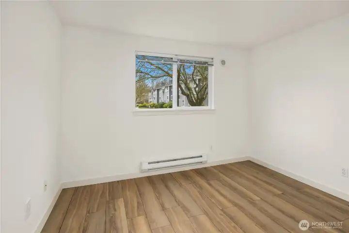 South facing bedroom #2. Fresh paint, 3 years old LVP flooring, and plenty of sunshine streaming in. This bedroom overlooks parking lot and building entrance.
