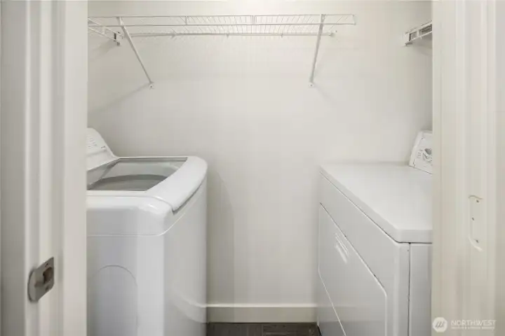 Laundry room in unit, in the bathroom. New top load washer machine, with convenient racks for storing everything you might need.