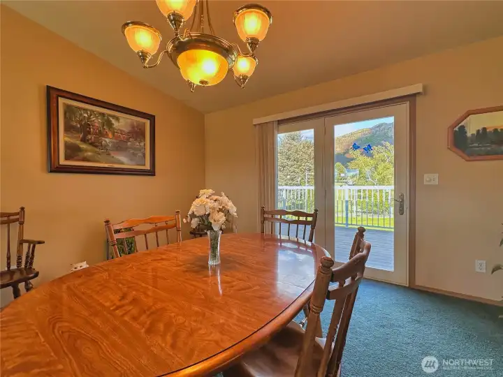 Dining room with French doors opening to the deck and adjoining patio, creating seamless indoor-outdoor living.