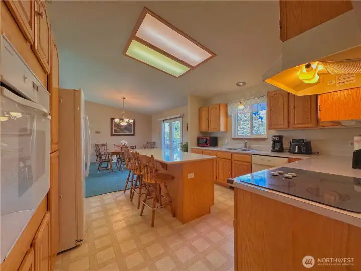 Convenient sleek glass-top range paired with a built-in wall oven and plenty of cupboard/counter space.
