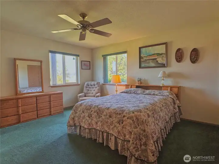 The primary bedroom is privately situated, with guest bedrooms on the opposite end of the home—creating a thoughtful split-bedroom layout.
