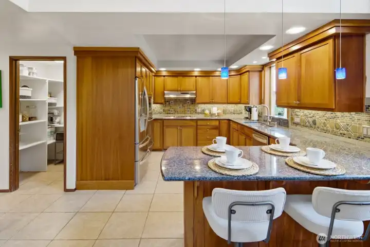 Chef-inspired kitchen with cherry cabinets, Granite slab counters, custom backsplash, SS appl., custom lighting & walk-in pantry.