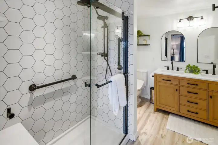 Beautifully updated Primary Suite bathroom with spacious walk-in shower with seating