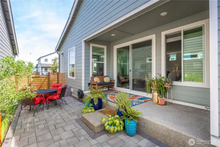 Covered upgraded patio with pavered patio and garden space.