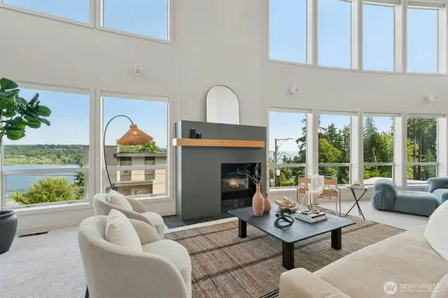2 story living room with soaring ceilings & walls of glass framing the lake & mountain views beyond